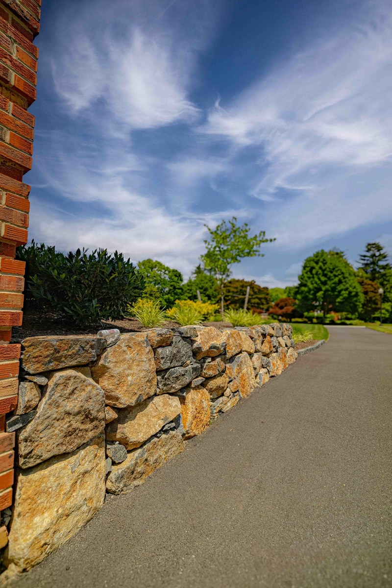Stone wall leading from brick corner with dramatic sky, Greenville Delaware