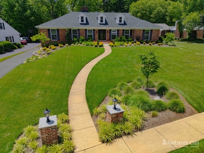 Aerial of walkway and brick pillars approaching Greenville DE home